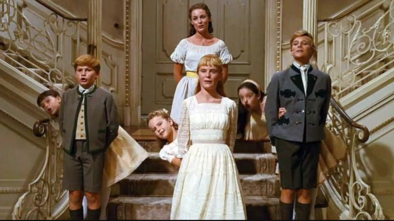 The children from The Sound of Music, singing and leaning, in formation. 