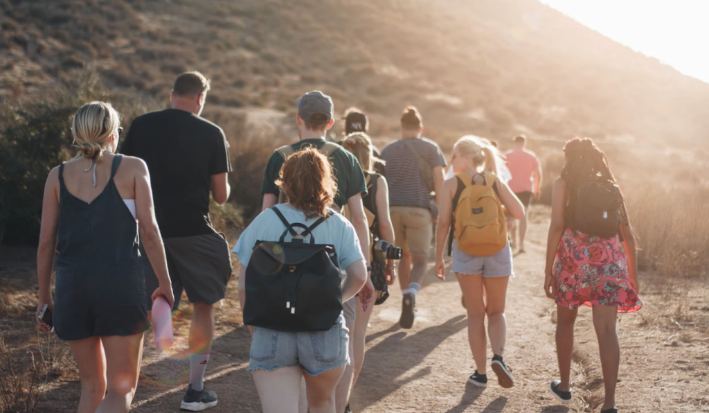 Group of people walking on sandy path in hills in summer. from Unsplash.