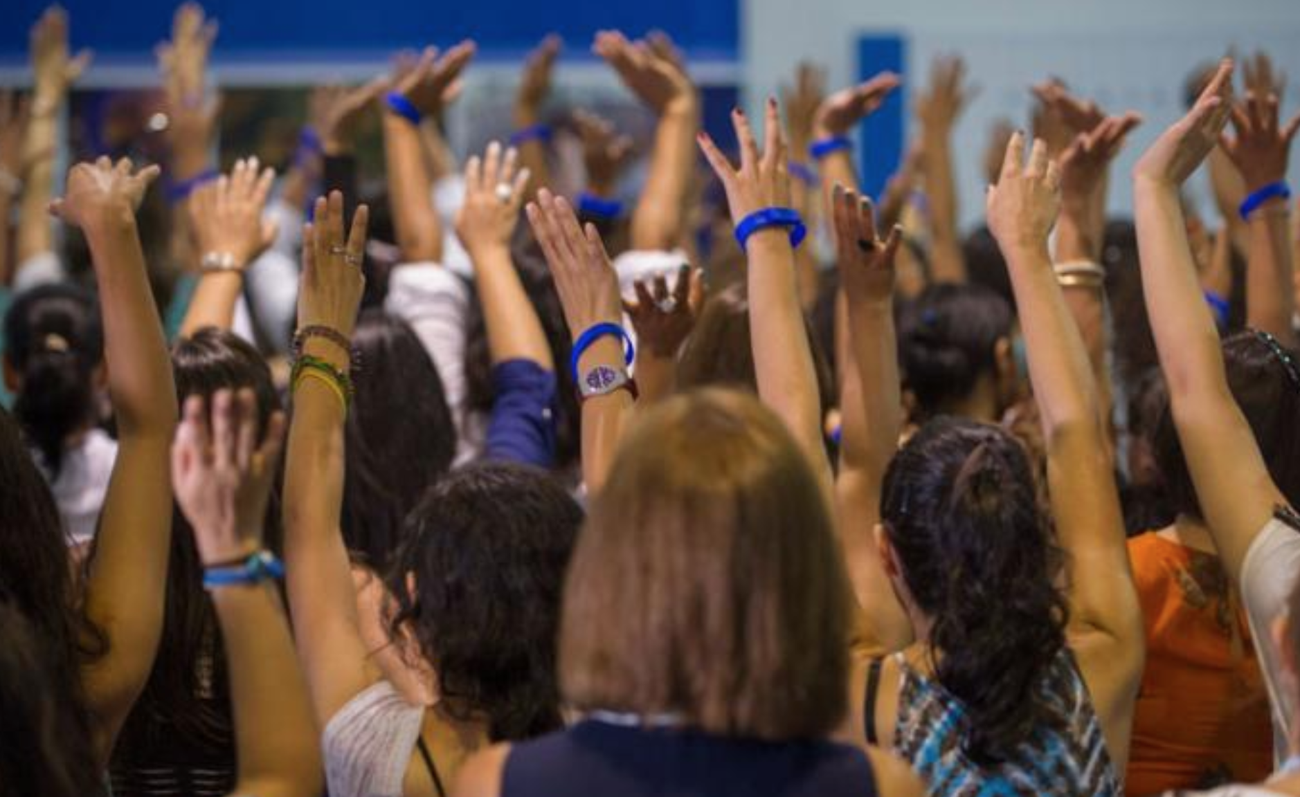 A crowd of women, all raising their hands.