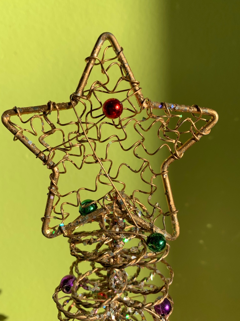 A decoration made of a star-shaped frame with curly wires extending across the inside to add to the solidity of the star.