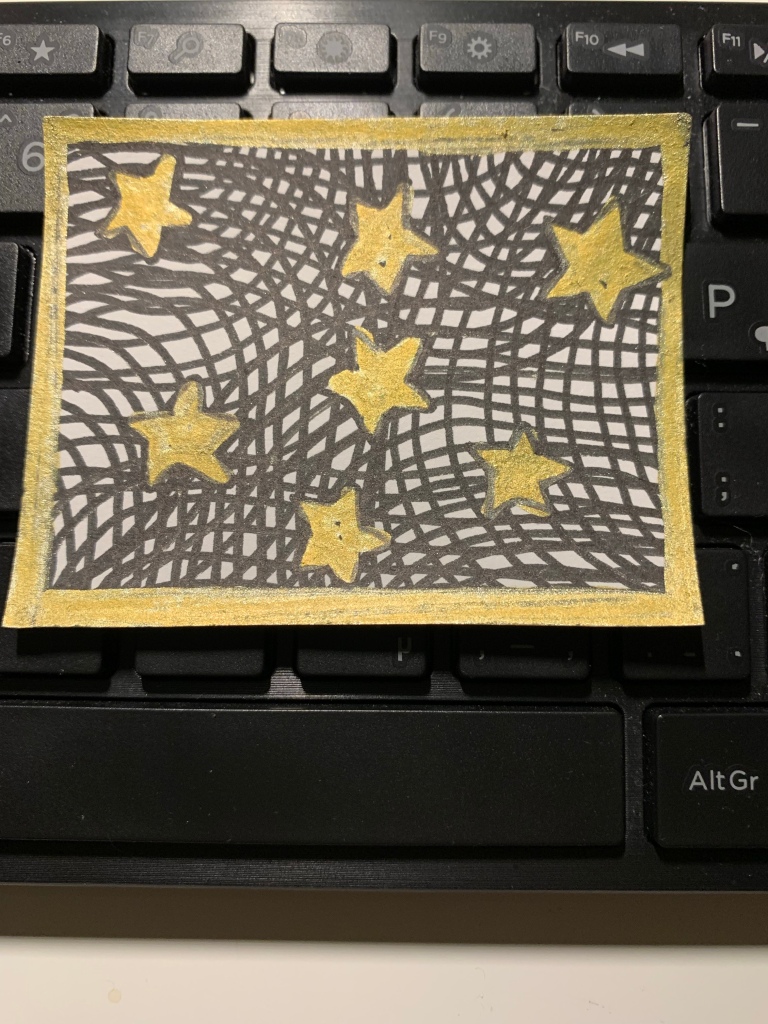 A small drawing of seven shiny gold stars against a background of overlapping curved lines. The drawing is resting on a black computer keyboard.